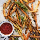 potato fries with rosemary laid out on paper