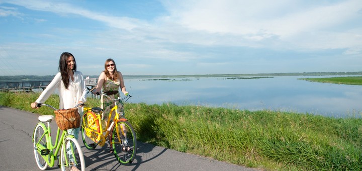 women walking with their bikes, Big Lake in the background