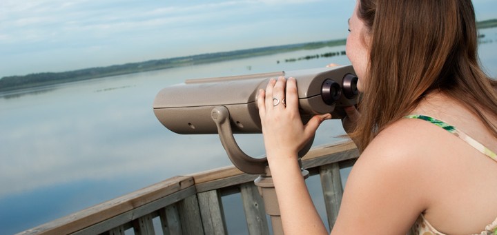 woman looking at Big Lake through binoculars