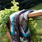 Colourful quilt hanging over deck railing