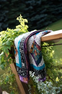 Colourful quilt hanging over deck railing