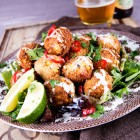 couscous & corn croquettes on bed of lettuce with lime