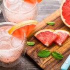 cocktail with grapefruit displayed with cutting board