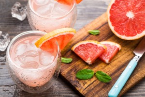 cocktail with grapefruit displayed with cutting board