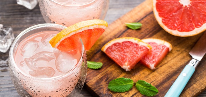 cocktail with grapefruit displayed with cutting board